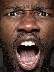 Close up portrait of young and emotional african-american man. Highly detail photoshot of male model with well-kept skin and bright facial expression. Concept of human emotions. Screaming.