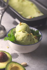 Homemade organic avocado and mint ice cream in a bowl with raspberries