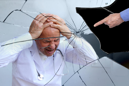 male doctor with a stethoscope around his neck covered his head with his hands, an accusing gesture, a concept of guilt, medical error, fatigue, problems