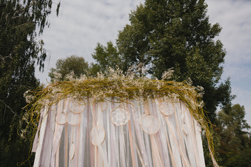 Fototapeta premium Coziness and style. Modern event design. Lounge zone and european traditional wedding ceremony decoration outdoors in the restaurant before the reception.