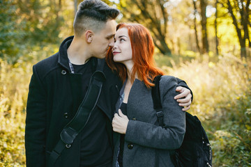Fototapeta premium Cute couple in a park. Lady with red hair. Guy with a guitar