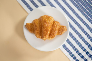 croissant on a yellow background, top view,breakfast