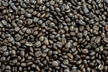 Brown roasted coffee beans, seed on dark background.