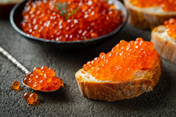 Delicious Sandwiches with red caviar on a dark concrete background