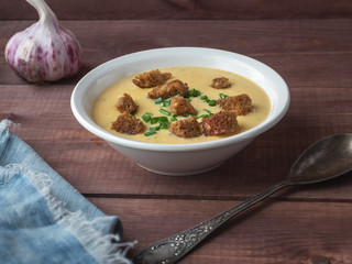 Cheese soup with rye bread croutons in a white deep plate