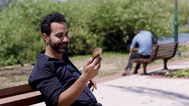 Laughing man watching a frustrated man smashing and throwing his phone to a river. 2 takes.