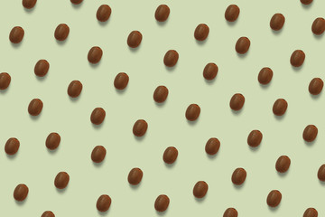 Summer brown kiwi pattern on the green pastel background. Tropical fruit wallpaper