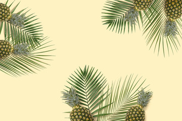 Top view  pineapple and kiwi flatlay. Summer minimal banner copyspace. Green palm leaves on the pastel background