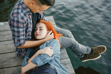 Cute couple in a park. Lady with red hair. Two people near water