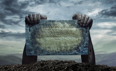 Zombie hand holding old wooden board, Empty space for text or draw