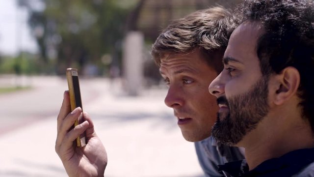 A man sneaking up to watch his friend's phone screen, get impressed. 4 takes.