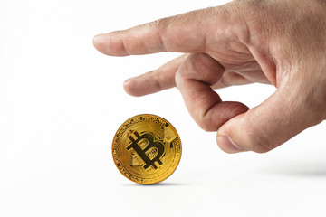 Man put bitcoin on edge and pulls it away kicking with index finger. Depreciation of virtual money...