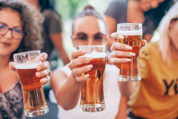 Happy group of best friends drinking beer - Friendship concept with young female friends enjoying time and having genuine fun at outdoor nature ambient