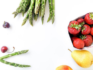 Fresh asparagus and strawberries isolated on white background, top view, flat layout. Space for text.