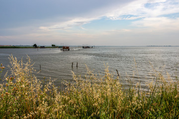 Padelloni, typical Emilia-Romagna fishing nets at the Lagoon of Comacchio, Province of Ferrara, Region of Emilia-Romagna, Italy, summer evening view