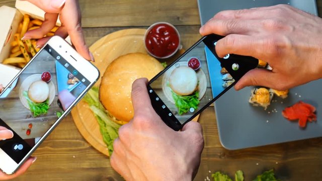 Friends using smartphones to take photos of food