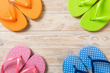 a lot of flip flop colored sandals, summer vacation on wooden background, copy space top view