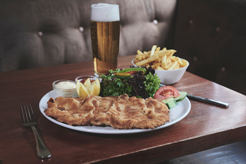 Wiener Schnitzel mit Pommes, Salat und Bier in einem Wiener Cafe 