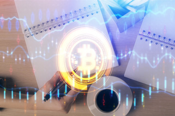 Cryptocurrency hologram over woman's hands writing background. Concept of blockchain. Double...