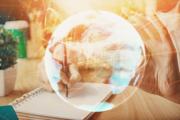 International business hologram over woman's hands taking notes background. Concept of success. Double exposure