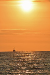 Naklejka na ściany i meble Golden Sunset at the Beach with Boat