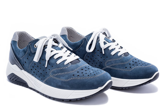 Close up of elegant light blue sports shoes in natural nubuck leather for adult men photographed on a white background. Fashion accessories.