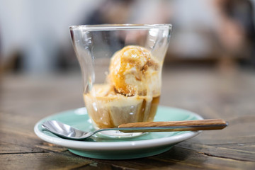 Affogato coffee with ice cream on wooden table.