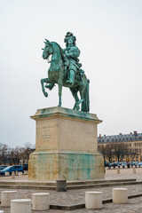 Fototapeta na wymiar Equestrian statue of Louis XIV on Place d'Armes in front of Palace of Versailles. Palace Versailles was a royal chateau.