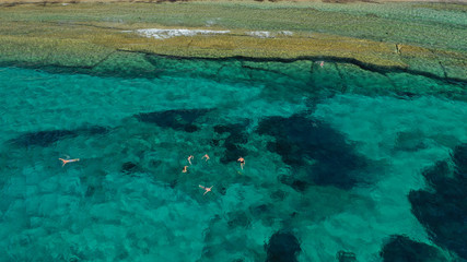 Aerial photo of famous sandy beach with turquoise clear sea of Megali Amos next to iconic and picturesque main town of Mykonos island, Cyclades, Greece
