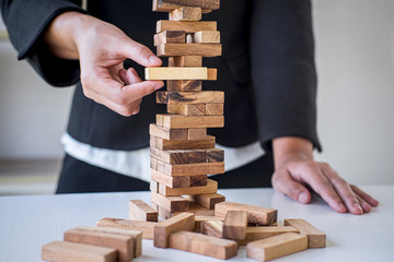 Alternative Risk and Strategy in Business, Hand of intelligent business woman gambling placing making wooden block hierarchy on the tower to planning and development to successful