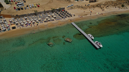 Aerial drone photo of famous organised with sun beds and umbrellas beach of  Paradise with emerald...