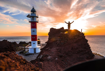 Lifestyle of a boy visiting the lighthouse at a sunset in Punta de Teno, Tenerife (Canary Islands)