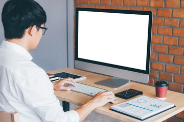 Image of Young man working in front of the computer laptop looking at screen with a clean white screen and blank space for text and hand typing information on keyboard in modern workspace