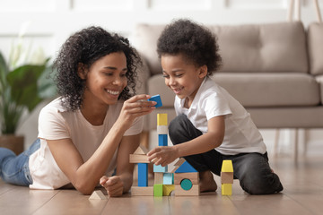African mother with little kid son play with wooden blocks
