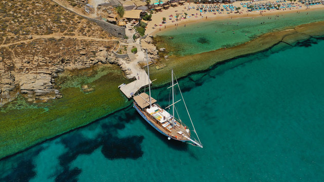 Aerial drone photo of famous organised with sun beds and umbrellas beach of  Paradise with emerald clear sandy sea shore, Mykonos island, Cyclades, Greece  