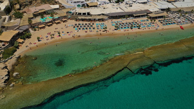 Aerial drone photo of famous organised with sun beds and umbrellas beach of  Paradise with emerald clear sandy sea shore, Mykonos island, Cyclades, Greece  