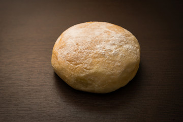 butter buns with powdered icing sugar on dark wood table