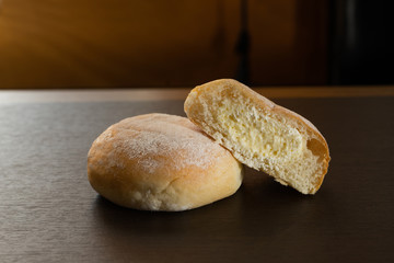 butter buns with powdered icing sugar on dark wood table