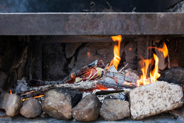 Close-up of the ashes and flames of a barbecue.