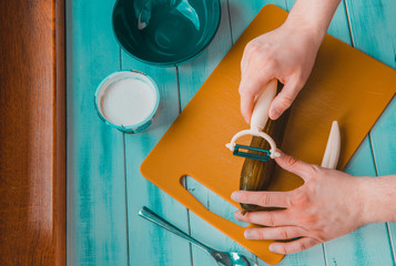 Top view of a man picking green cucumber. The concept of preparing a salad, salad and dinner. Healthy food and taking care of yourself and your appearance.