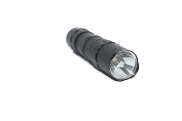 small black flashlight tactical for camping and hiking trails isolated on white background