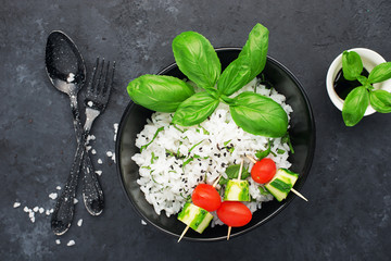 Rice ready with ginger and basil for a healthy diet. View from above on a dark background. Vegetarian diet dish