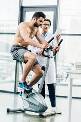 beautiful doctor with digital tablet near shirtless sportsman during endurance test