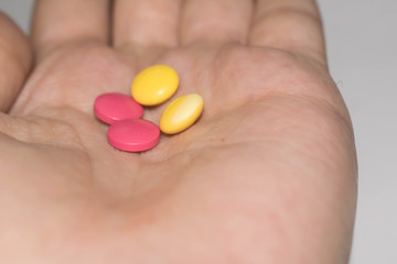 Pills medication handful in hand round pink yellow for medicine design
