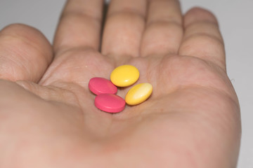 Pills medication handful in hand round pink yellow for medicine design