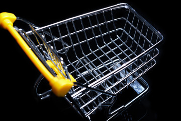 Close-up of shopping carts on black background.Trolley, Sale concept.Empty grocery shopping cart. Isolated over black background.