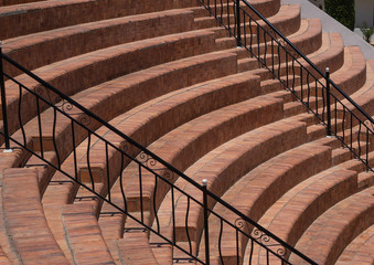 semicircular steps in the amphitheater sector with black metal railings, brickwork, a fragment of the seats - steps