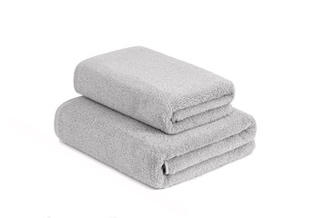Gray terry towels folded and stacked isolated. Terry towels against white backdrop. Folded soft bath towels. Stack of cotton towels on a white background