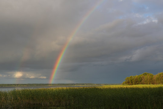Rainbow over the lake in cloudy weather © makedonski2015