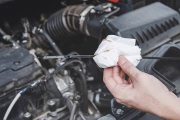 Services car engine machine concept, Automobile mechanic repairman hands checking a car engine automotive with oil level in the engine transportation, car service and maintenance
